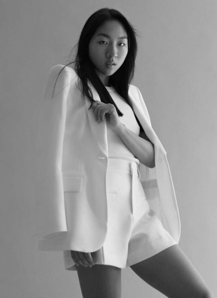 Model posing for photoshoot in a white outfit