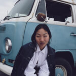 Petite model posing in front of a volkswagon van