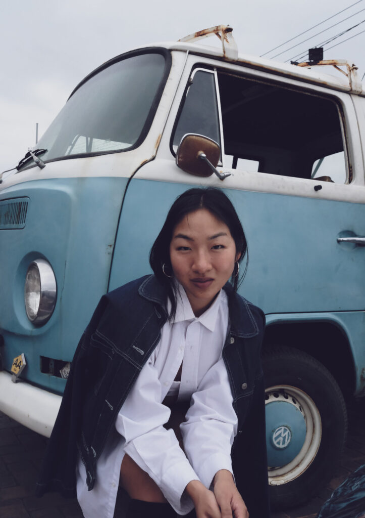 Petite model posing in front of a volkswagon van