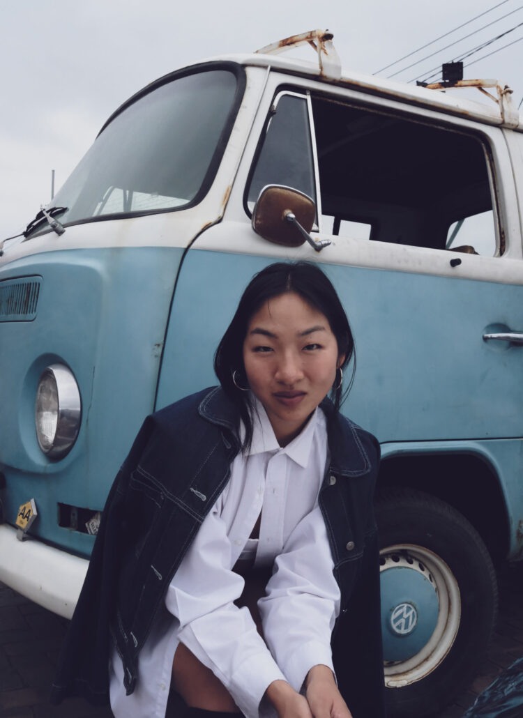 Petite model posing in front of a volkswagon van